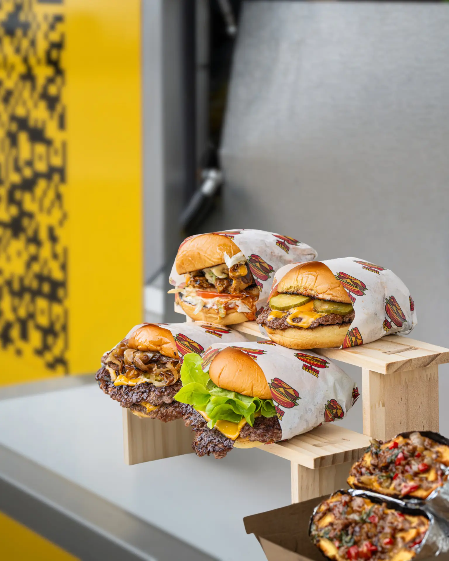 Wrapped T8STE DEEZ burgers and loaded fries on display
